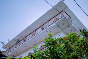 a building with balconies and trees in the foreground at King Palace Mirissa in Mirissa