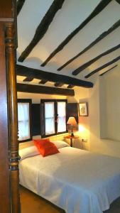 - une chambre avec un lit doté de draps blancs et de fenêtres dans l'établissement Casa Rural Las Pedrolas, à Arnedillo