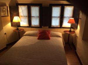 a bedroom with a bed with two lamps on two tables at Casa Rural Las Pedrolas in Arnedillo