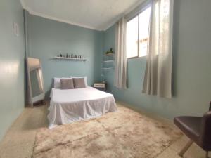 a bedroom with a white bed in a blue room at Pachamec House in Guayaquil