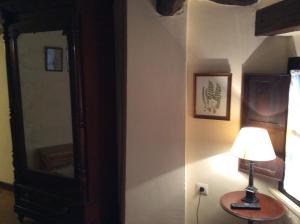 una lámpara sentada en una mesa junto a un espejo en Casa Rural Las Pedrolas, en Arnedillo