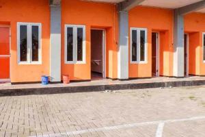 a row of orange doors on a building at Artayya Puri 2 near Alun Alun Caruban Mitra RedDoorz in Madiun