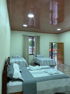 a bedroom with two beds and a ceiling at Hospedaje Alejandra in Canoas