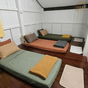 a room with three beds sitting on the floor at NiranHouse Hostel in Sathani Phitsanulok +74 photos