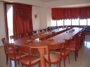 uma grande sala de conferências com uma mesa longa e cadeiras em Valley View Hotel - Hammana em Ḩammānā