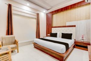 a bedroom with a large bed and a window at Townhouse Oak Dehradun Court Formerly GK Residency in Dehradun