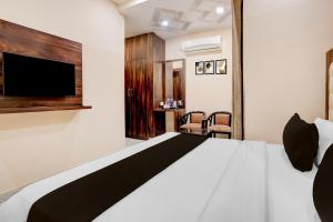 a hotel room with a bed and a tv at Townhouse Oak Dehradun Court Formerly GK Residency in Dehradun +39 photos