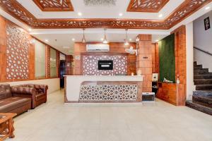 a lobby with a fireplace and a couch and stairs at Townhouse Oak Dehradun Court Formerly GK Residency in Dehradun