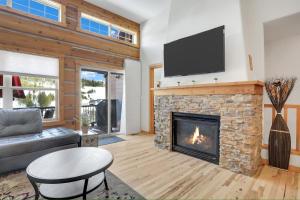 a living room with a fireplace with a flat screen tv at Majestic Views - Steps to the Trails in Fraser