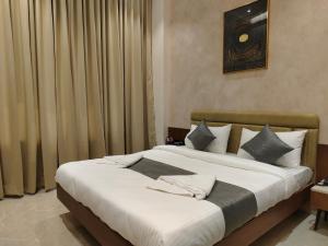 a bedroom with a large bed with white sheets and pillows at Hotel Raas Vrindavan in Laling