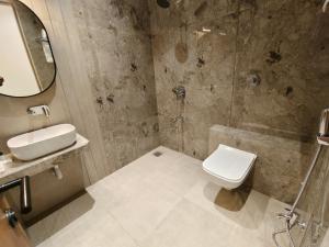 a bathroom with a toilet and a sink and a shower at Hotel Raas Vrindavan in Laling