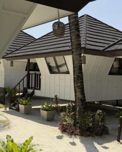 a patio with a black and white umbrella and plants at Casitas de Boracay in Boracay