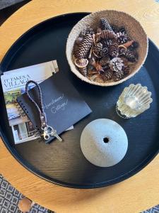 a table topped with a plate with a bowl of shells at Hurstmere Cottage, Matakana in Matakana