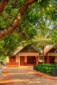 a building with a palm tree in front of it at Green Planet Resort in Mattanūr