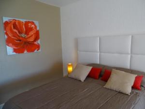 a bedroom with a bed with red and white pillows at Charmant Studio Vue Mer Village Soleil in Le Gosier +17 photos