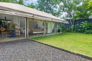 a patio with a swing and a yard at Origin Uluwatu in Uluwatu