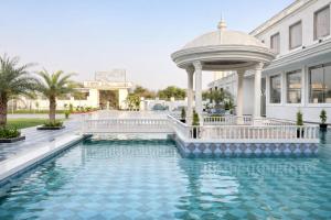 a pool in front of a building with a gazebo at Orchha River Stone Resort in Orchha