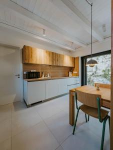 a kitchen with white cabinets and a wooden table at Up and above in Kobarid