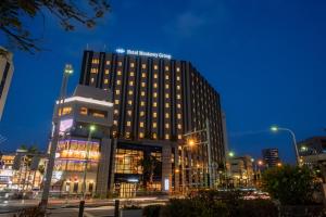 a tall building in a city at night at Hotel Monterey La Soeur Naha in Naha