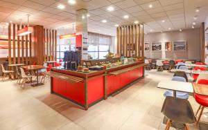 a restaurant with a red counter and tables and chairs at ibis Buenos Aires Obelisco in Buenos Aires