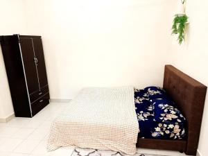 a bedroom with a bed and a black cabinet at SuaTamu Homestay One Aircond in Kamunting +2 photos