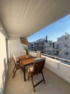 a balcony with a wooden table and chairs at The Costa Suite byArtistunknown in Vari