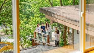 a group of people standing on a balcony of a house at Mungyeong Between Mountains Pet Pension in Mungyeong