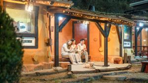 a group of people sitting on a bench in a house at Mungyeong Between Mountains Pet Pension in Mungyeong +1 photo
