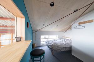 ein Schlafzimmer mit einem Bett und einer blauen Wand in der Unterkunft NOMAyado in Naruto
