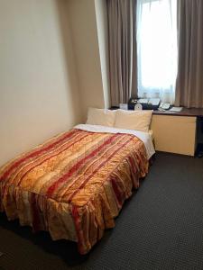 a bed in a hotel room with a window at Shingu Central Hotel in Shingū +21 photos