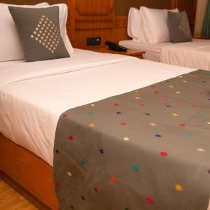 a bedroom with two beds with confetti on the blanket at Amba Paro in Paro