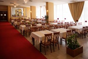 a restaurant with white tables and chairs and a red carpet at Hotel San Terme Laktaši in Laktaši