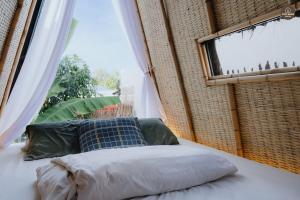 a bed in a room with a large window at mango house, hide out Can Tho in Ấp Bình Thương