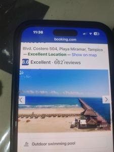a cell phone screen with a picture of a beach at Arenas del mar in Monterrey