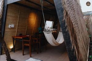 a hammock hanging in a room with a table at mango house, hide out Can Tho in Ấp Bình Thương +18 photos