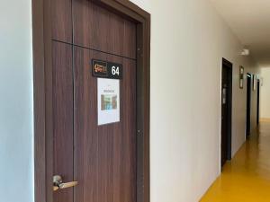 a wooden door in a hallway with a sign on it at Green Gen Hotel Phuket in Phuket +157 photos