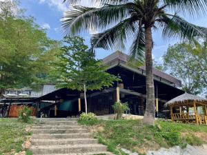 a building with a palm tree in front of it at Green Gen Hotel Phuket in Phuket