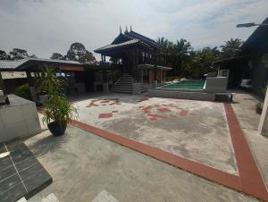 a house with a patio and a building at Tein roomstay in Rengit +1 photo