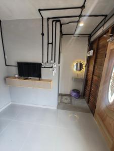 an empty room with a tv and a door at Tein roomstay in Rengit