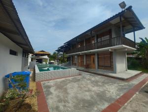 a house with a swimming pool in front of it at Tein roomstay in Rengit