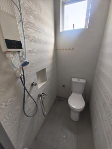 a small bathroom with a shower and a toilet at Tein roomstay in Rengit