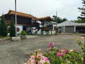 a house with flowers in front of it at Tein roomstay in Rengit
