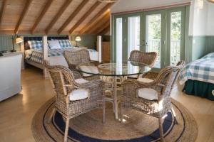 a dining room with a glass table and wicker chairs at Valhalla The Loft (Oceanfront Hot tub) in Salt Spring Island