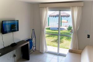 a living room with a sliding glass door with a view of the ocean at Pousada Holiday in Florianópolis