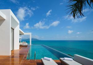 an infinity pool with the ocean in the background at Cape Azure Resort Samui by Thalsea in Plai Laem