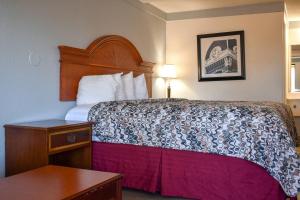 a hotel room with a bed and a table at Rodeway Inn Auburn Hills - Detroit in Auburn Hills +39 photos