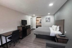 a hotel room with a bed and a desk and a television at Quality Inn Mt Pleasant in Mount Pleasant +17 photos
