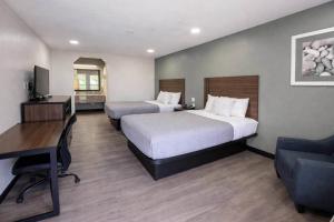 a hotel room with two beds and a desk at Quality Inn Mt Pleasant in Mount Pleasant
