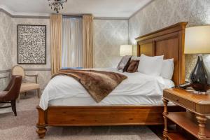 a bedroom with a bed and a table with a lamp at The Fort Garry Hotel, Spa and Conference Centre, an Ascend Collection Hotel in Winnipeg