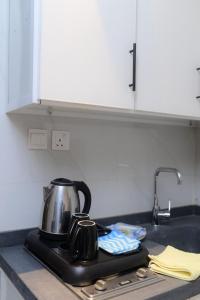 a tea kettle sitting on a stove in a kitchen at شقق نور الفخامه المخدومه in Buraydah